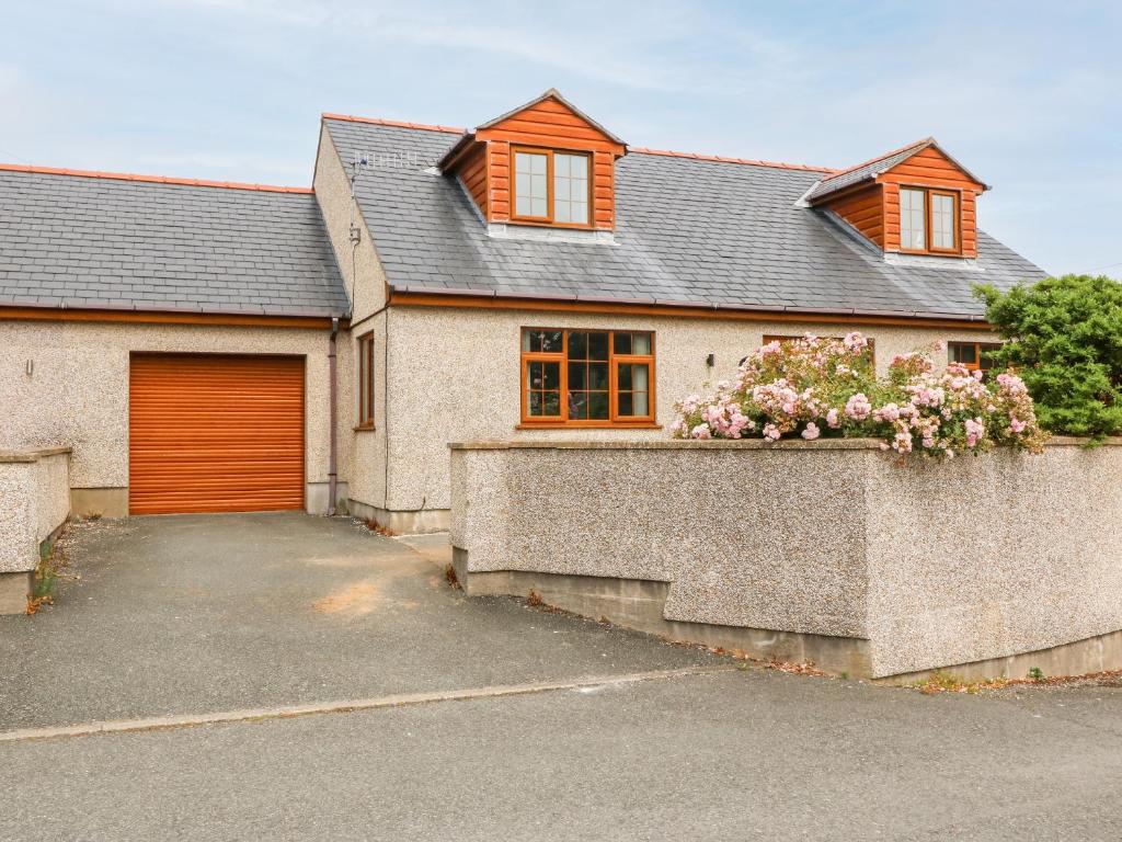a house with a orange door and a driveway at Yr Hen Efail in Cemaes Bay