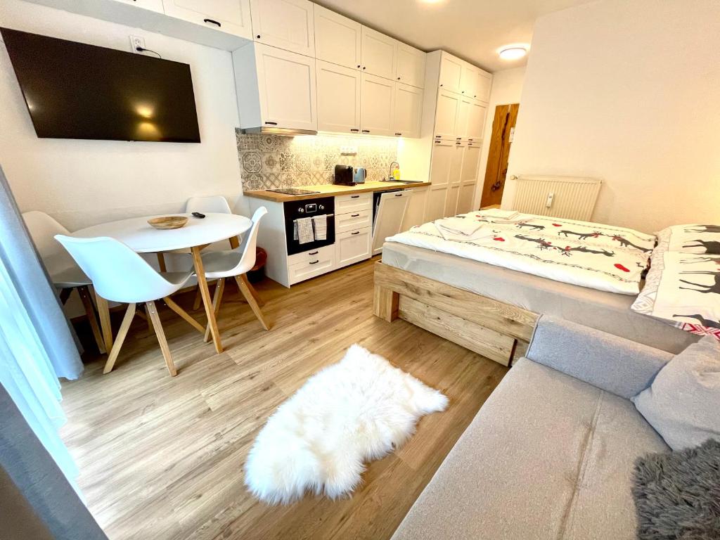 フィリップシュロイトにある2022 Neu renoviert- Apartments Michaelaのベッド1台、テーブル(白い敷物付)が備わる客室です。