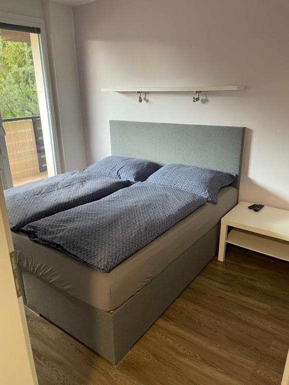 a bed in a bedroom with a large window at Všemina apartmán 31 in Všemina