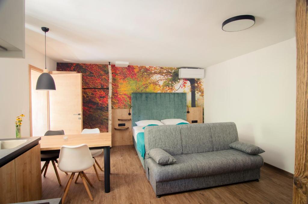 a bedroom with a bed and a table and a chair at Apartments with SAUNAS - Gobi in Podčetrtek