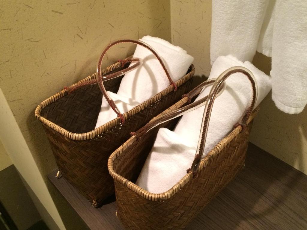 two baskets filled with towels in a bathroom at Takayama Ouan in Takayama