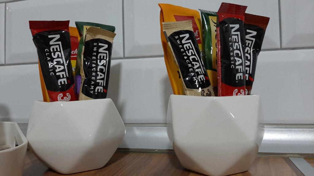 two white vases sitting on a table with snacks at Apartman 222 in Brčko