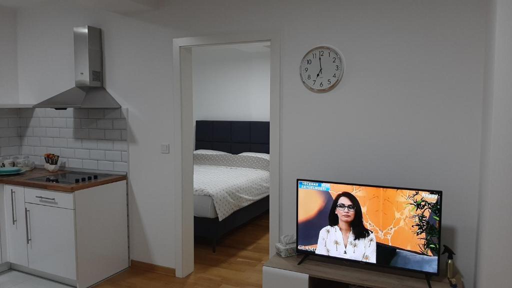 a room with a tv in a kitchen with a bed at Apartman 222 in Brčko