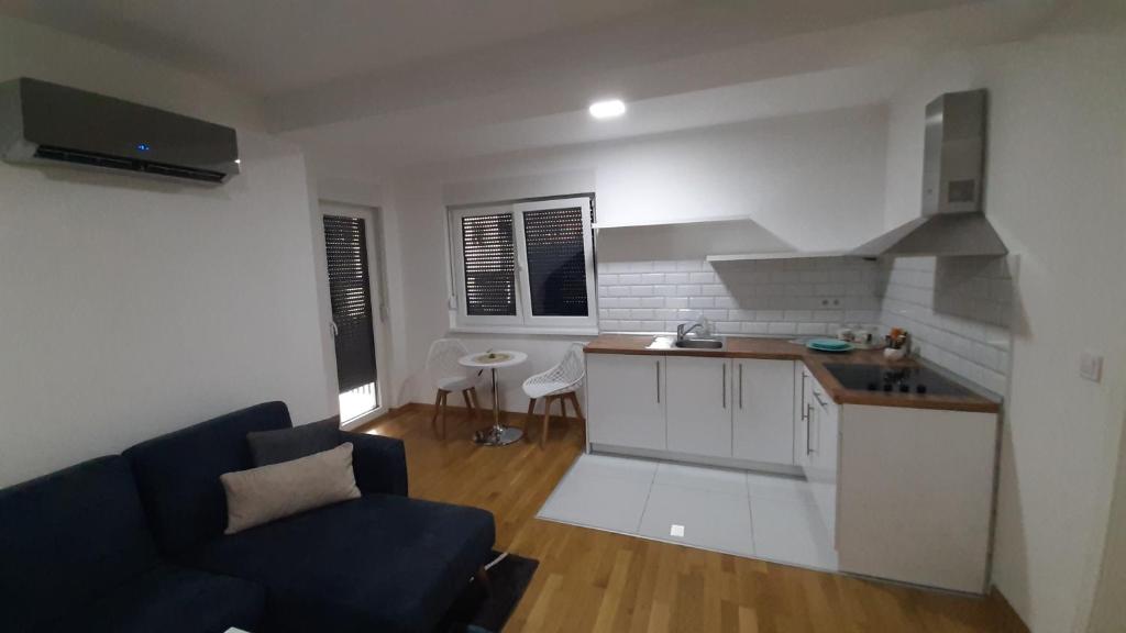 a kitchen and living room with a couch and a table at Apartman 222 in Brčko