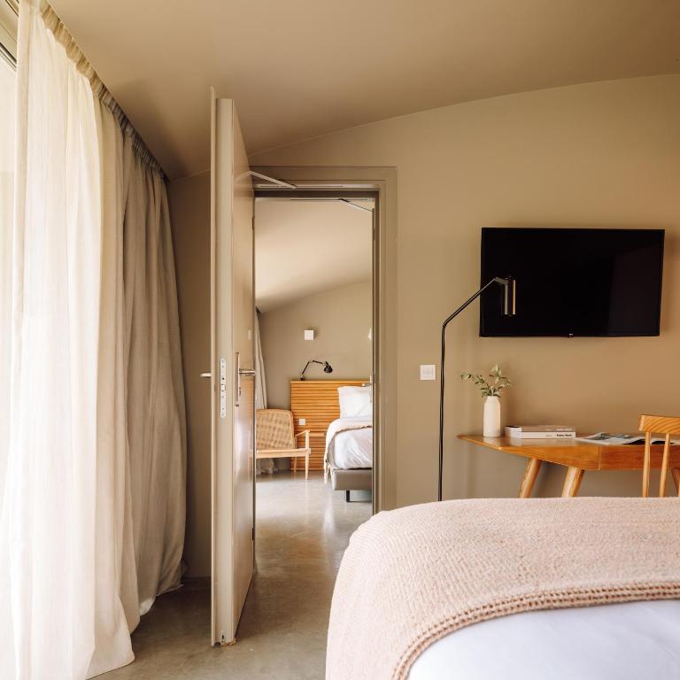 a bedroom with a bed and a table with a television at Immerso Hotel, a Member of Design Hotels in Ericeira