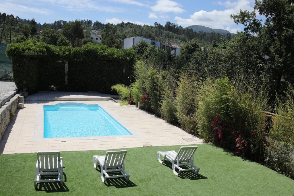 2 sillas y una piscina en un patio en Casa dos Remendos - Alojamento Local en Termas de Sao Pedro do Sul