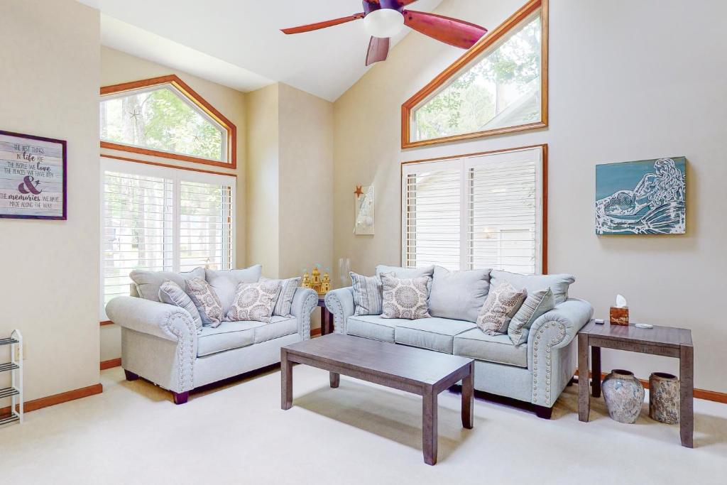a living room with two couches and a ceiling fan at Trinity Place Treasure in Ocean Pines