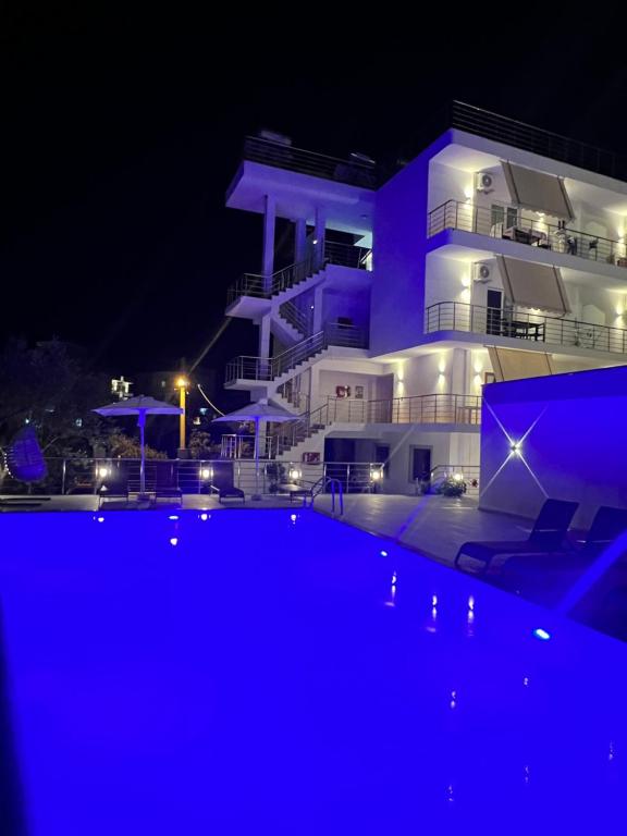 a building with a swimming pool in front of it at night at Apartments Mario in Ksamil