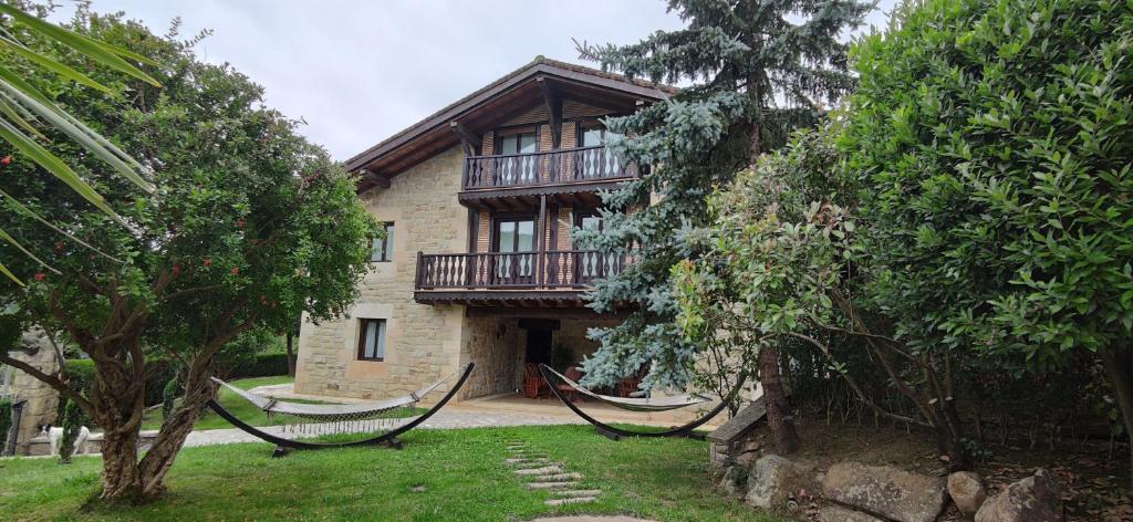 a house with a balcony on the side of it at Villa DOLARETXE in Barroeta