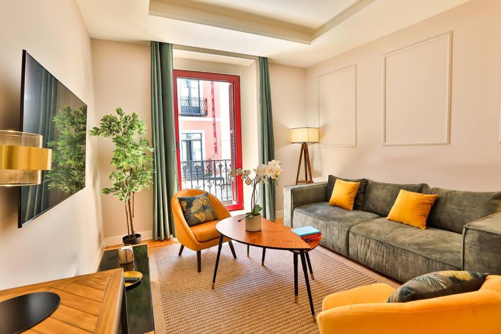 ein Wohnzimmer mit einem Sofa und einem Tisch in der Unterkunft #Madrid Centro. 3D. Gran Via. Callao.Puerta del Sol in Madrid