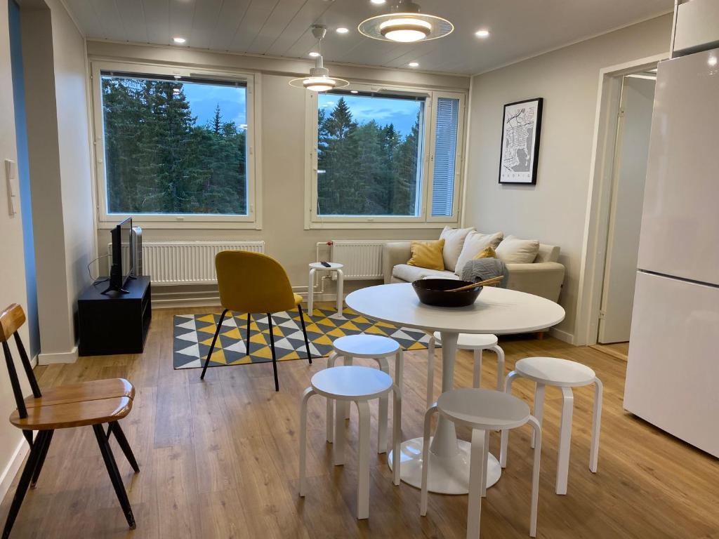 a kitchen and living room with a table and chairs at Moderni ullakkohuoneisto in Kuopio