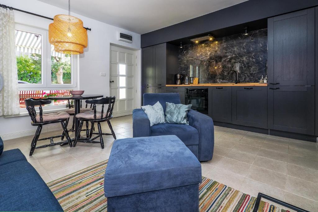 een woonkamer met blauwe meubels en een tafel bij Apartment Mendula in Split