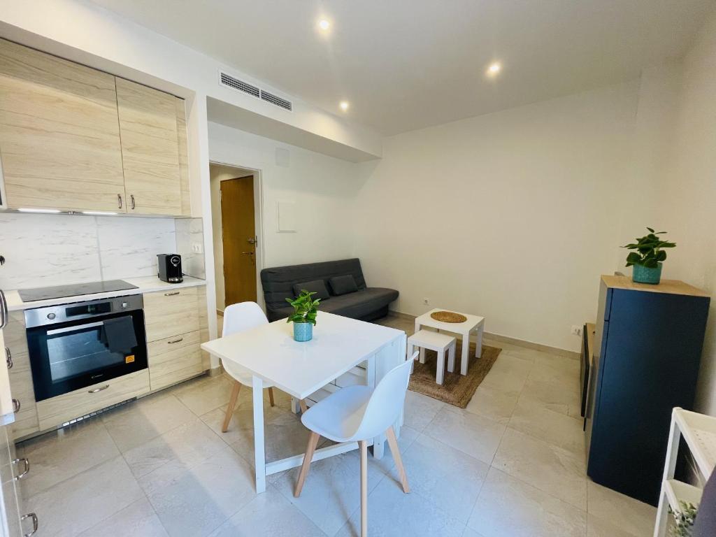 eine Küche und ein Wohnzimmer mit einem Tisch und einem Sofa in der Unterkunft NICE CENTRIC APARTMENT in Vilanova i la Geltrú