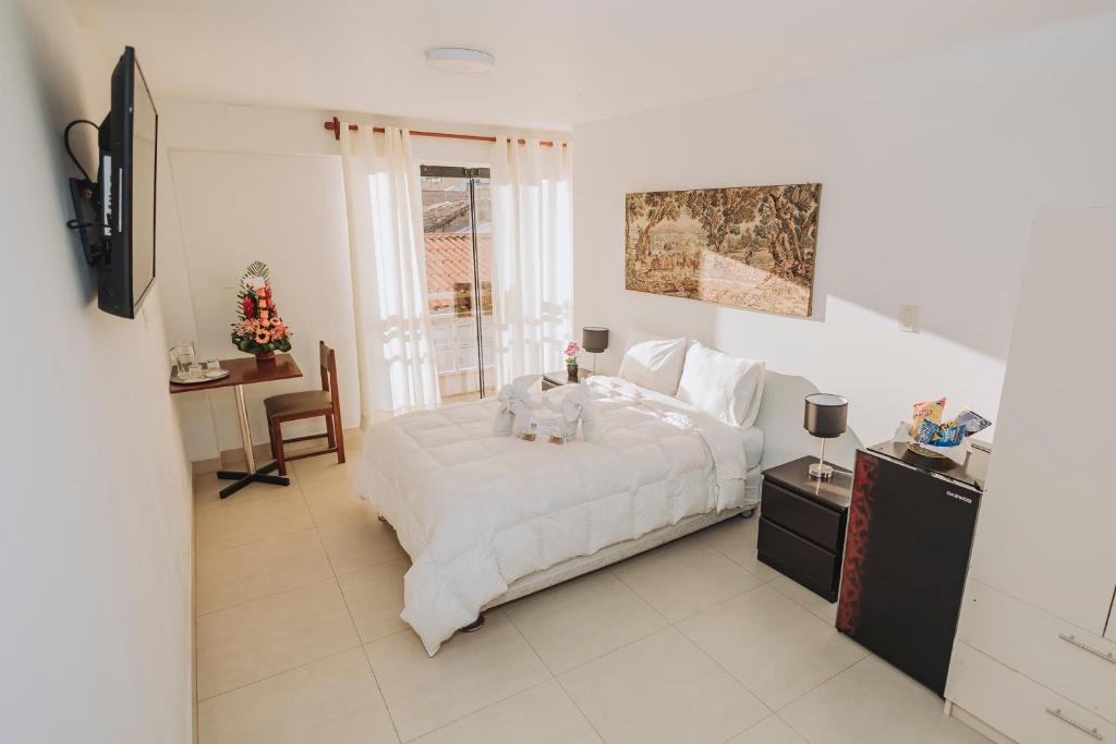 - une chambre avec un lit blanc et un chien dans l'établissement Hotel Los Reyes, à Cajamarca