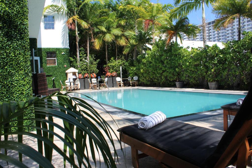 - une piscine avec une table et des chaises à côté dans l'établissement San Juan Hotel Miami Beach, à Miami Beach