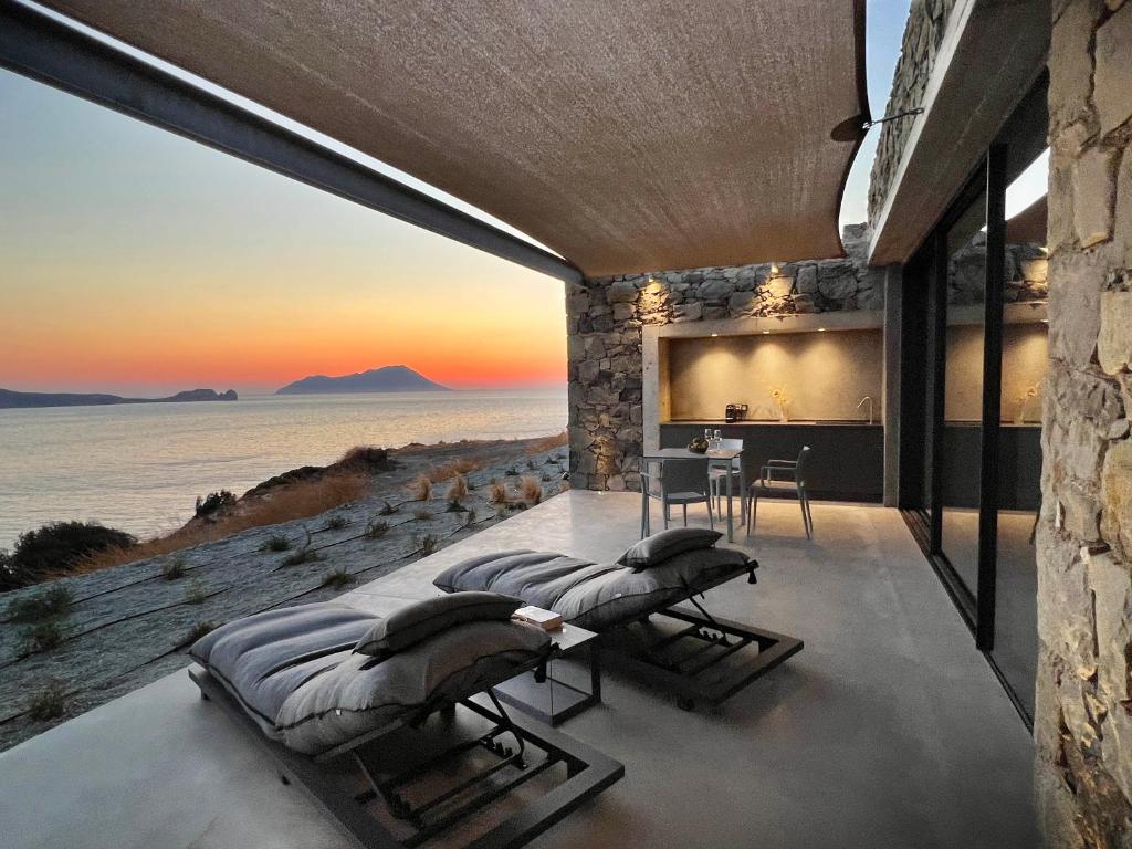 een slaapkamer met uitzicht op de oceaan bij Echoes Exclusive Suite in Kástron