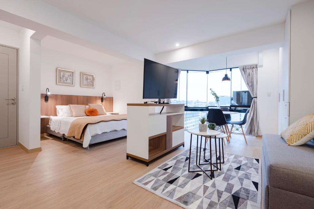 um quarto com uma cama e uma televisão num quarto em ALU Apartments - Miraflores f/Doubletree Hilton c/AC Wifi+60M em Lima