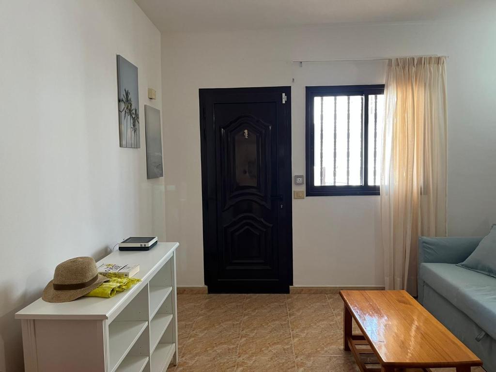 a living room with a blue couch and a door at Apartamento Playa Honda in Playa Honda