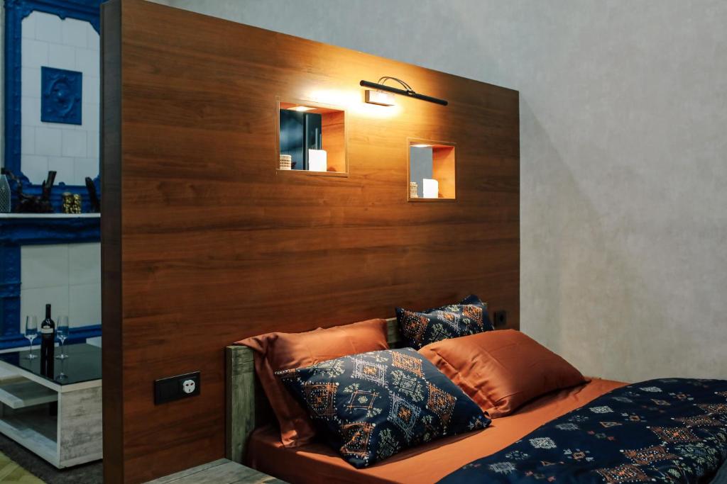 sypialnia z drewnianym zagłówkiem i łóżkiem z poduszkami w obiekcie Apartment Alexandra w mieście Tbilisi City