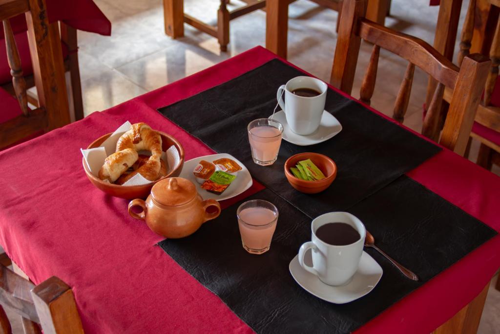 a table with a breakfast of coffee and pastries on it at Caminos Hostal in San Salvador de Jujuy