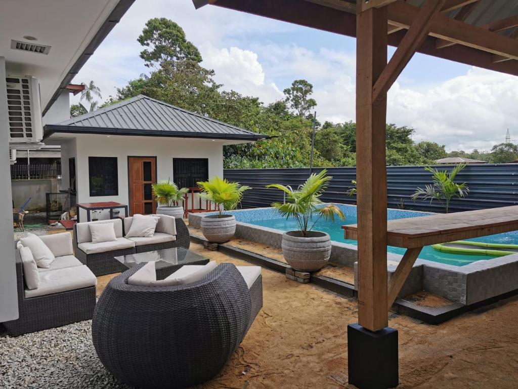 un patio trasero con piscina y una casa en Tropical appartement en Paramaribo