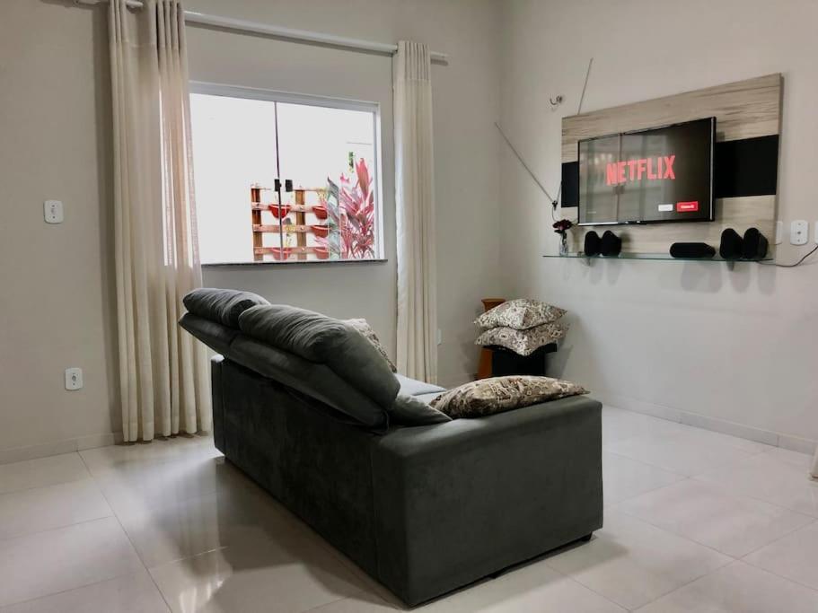 ein Sofa im Wohnzimmer mit Fenster in der Unterkunft Casa dos Ventos Barreirinhas in Barreirinhas