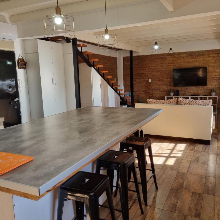 a large kitchen with a large table and stools at M&M Depto in Cipolletti