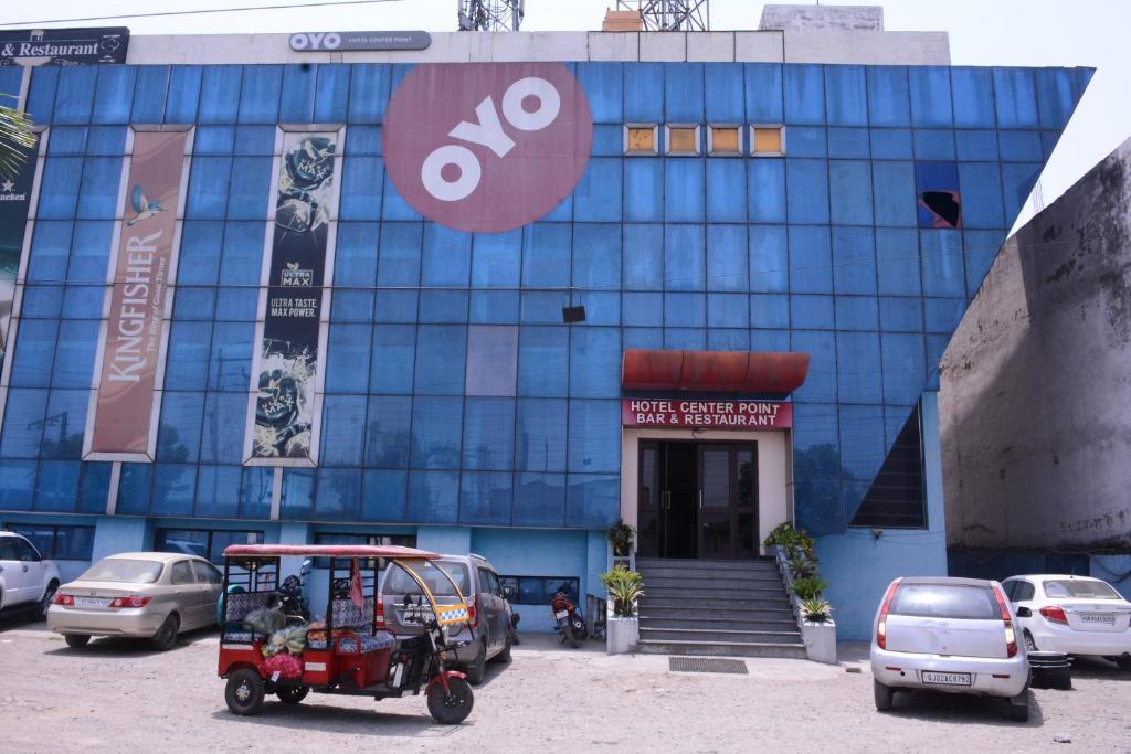 a red golf cart parked in front of a blue building at CENTER POINT in Rudrapur