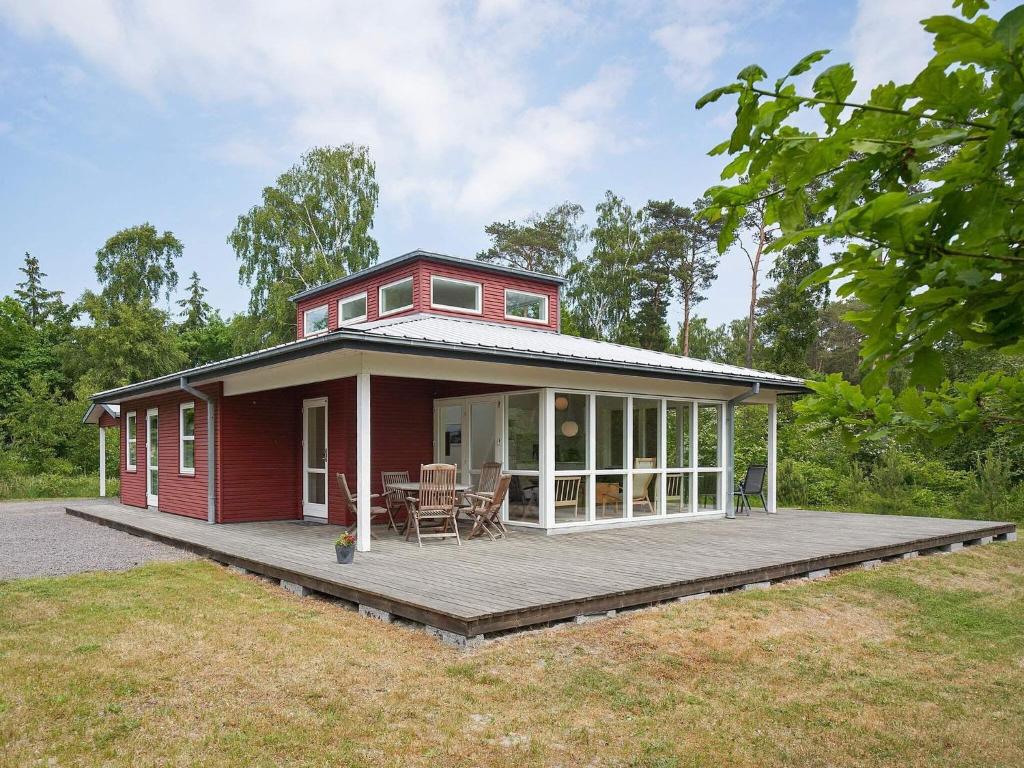a red house with a porch and a deck at Holiday home Aakirkeby XXXV in Vester Sømarken