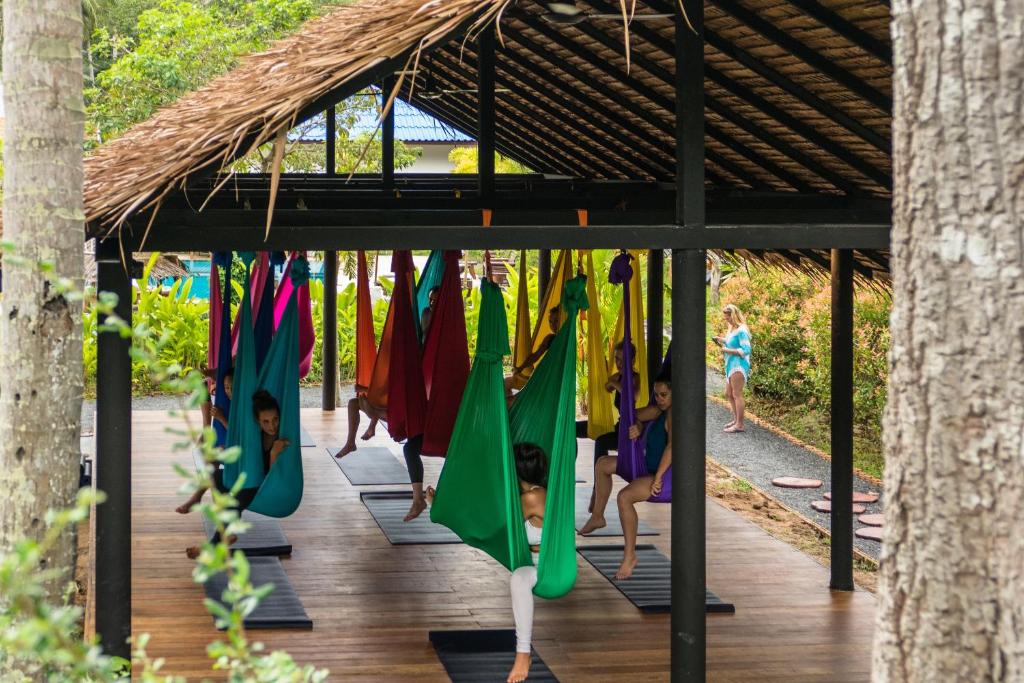 a group of children playing in a yoga class in a bamboo structure at Wonderland Healing Center in Thongsala