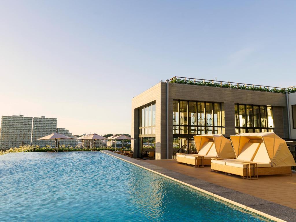 a hotel with a swimming pool and a building at MB GALLERY CHATAN by THE TERRACE HOTELS in Chatan