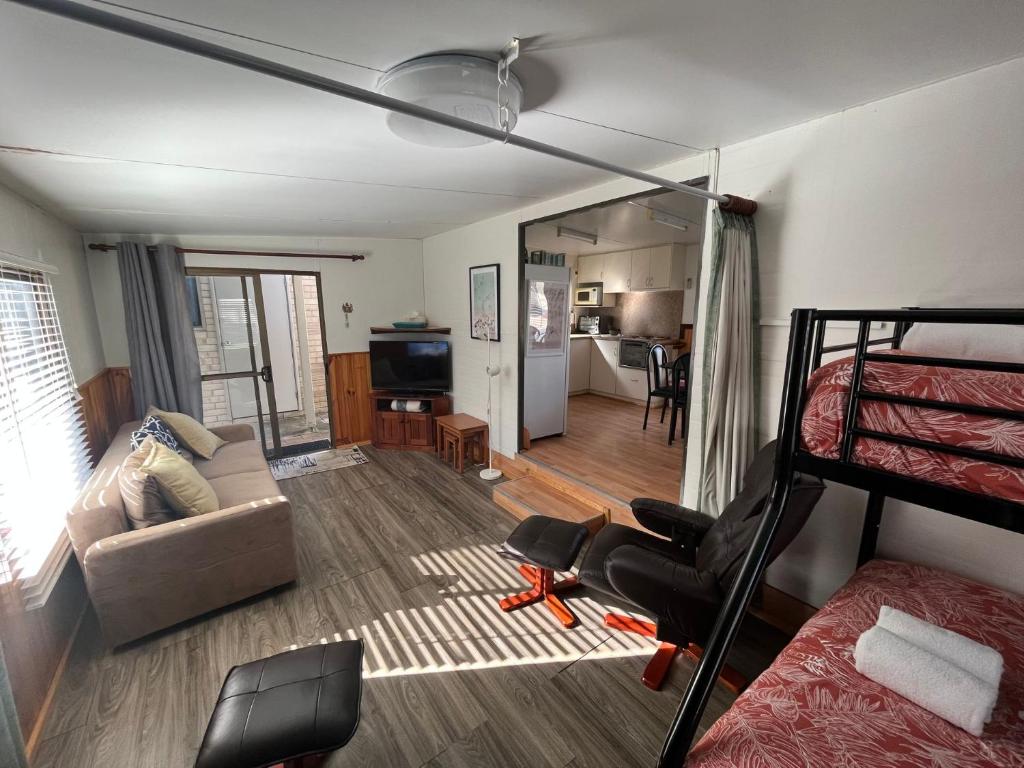 a bedroom with a bunk bed and a living room at Goin Coastal in Busselton