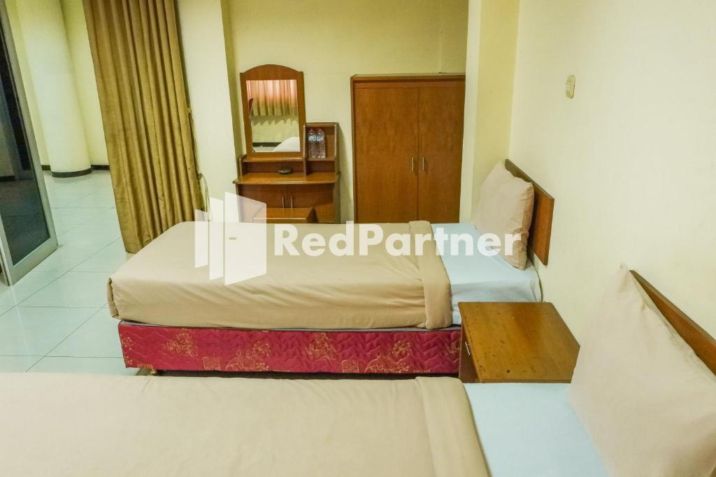 Postel nebo postele na pokoji v ubytování Grand Kembar Hotel Mitra RedDoorz