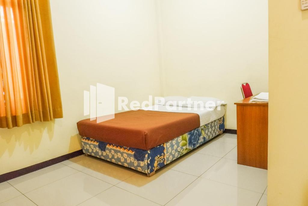 Postel nebo postele na pokoji v ubytování Grand Kembar Hotel Mitra RedDoorz