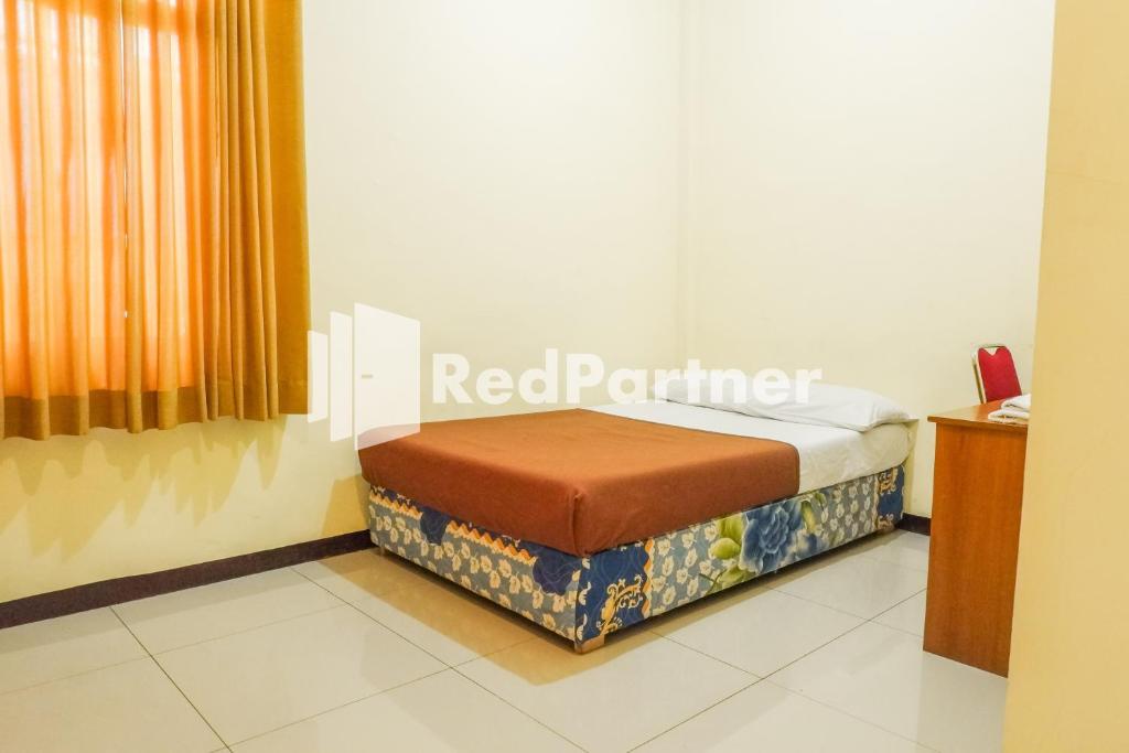 Postel nebo postele na pokoji v ubytování Grand Kembar Hotel Mitra RedDoorz