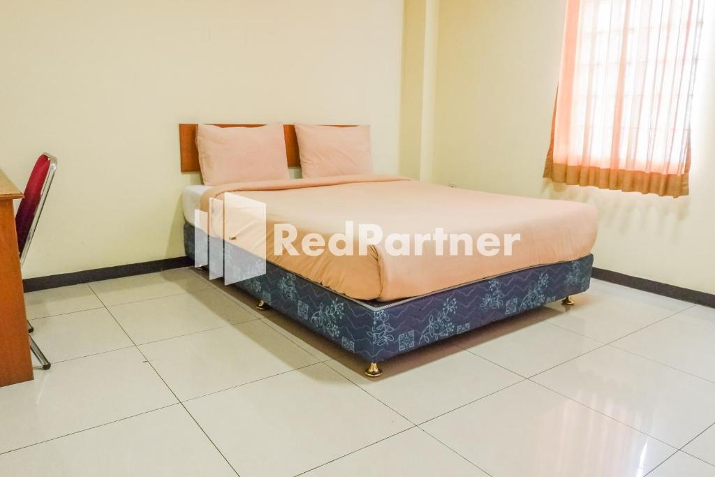 Giường trong phòng chung tại Grand Kembar Hotel Mitra RedDoorz