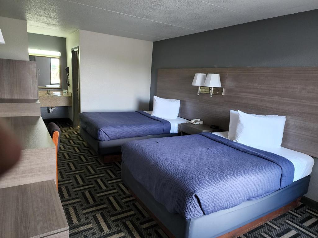 a hotel room with two beds in a room at Drakes Creek Inn - formerly The Relax Inn in Hendersonville