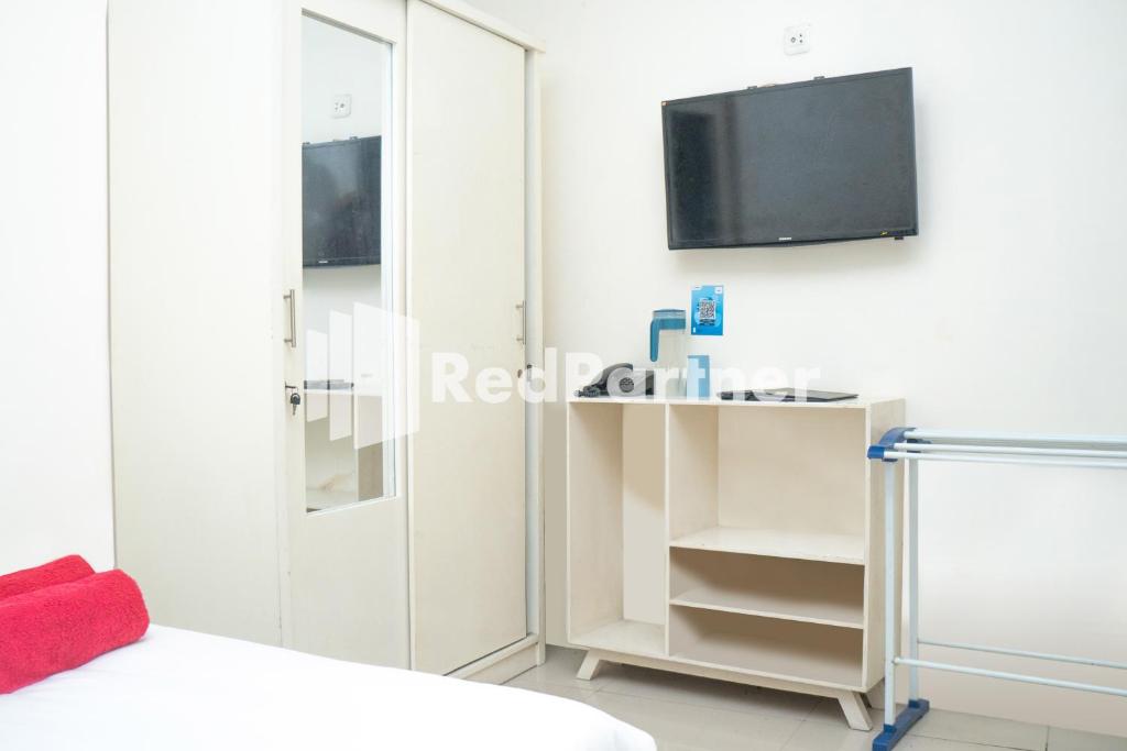 A television and/or entertainment centre at Jabrix Hotel Mitra RedDoorz