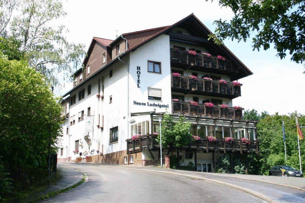 Hotel Ludwigstal في شريسهايم: مبنى فيه علب ورد على البلكونات على شارع