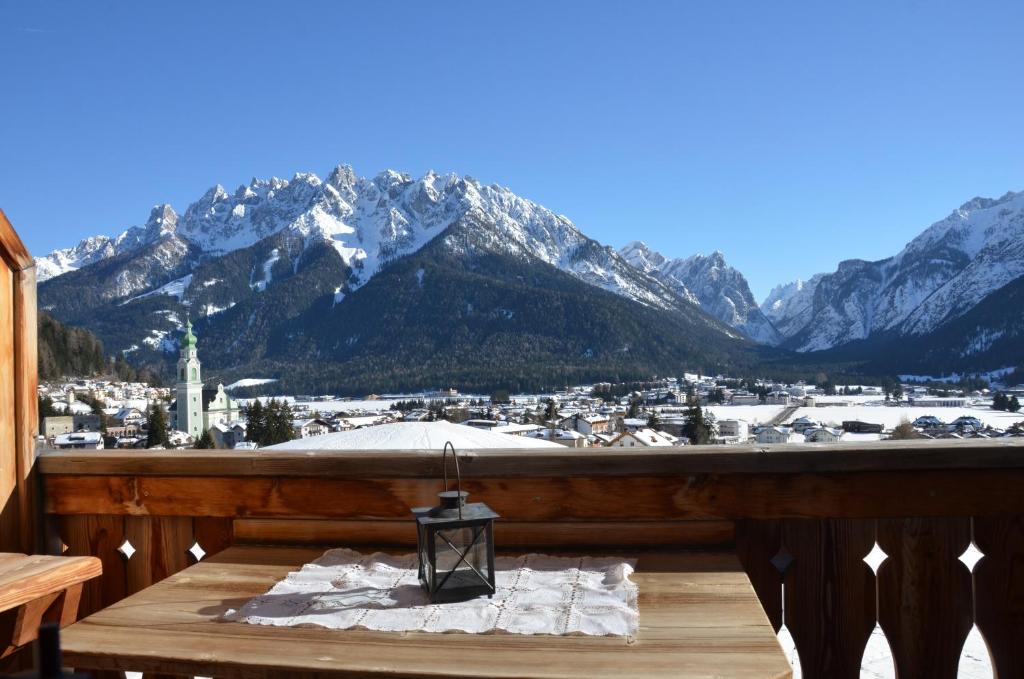 a table on a balcony with a view of mountains at Klaudehof in Dobbiaco