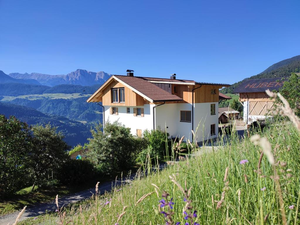 a house on a hill with mountains in the background at Huberhof in Villandro