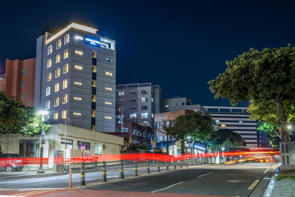 a city street at night with a tall building at Cornerstone Hotel in Seogwipo