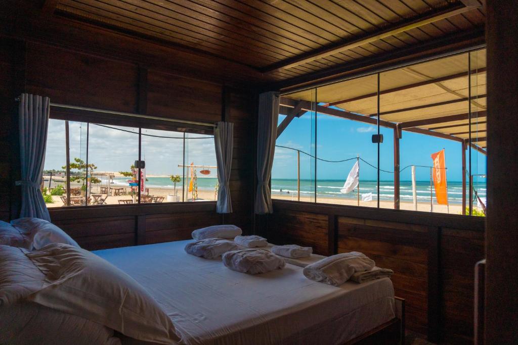 a bedroom with a bed with a view of the beach at Grand Fortim Maceio Praia in Camocim