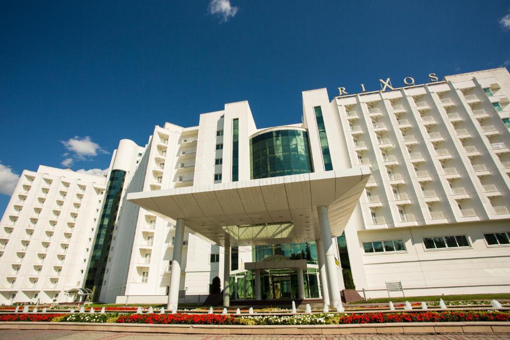 a large white hotel with a building with a sign on it at Rixos-Prykarpattya Resort in Truskavets