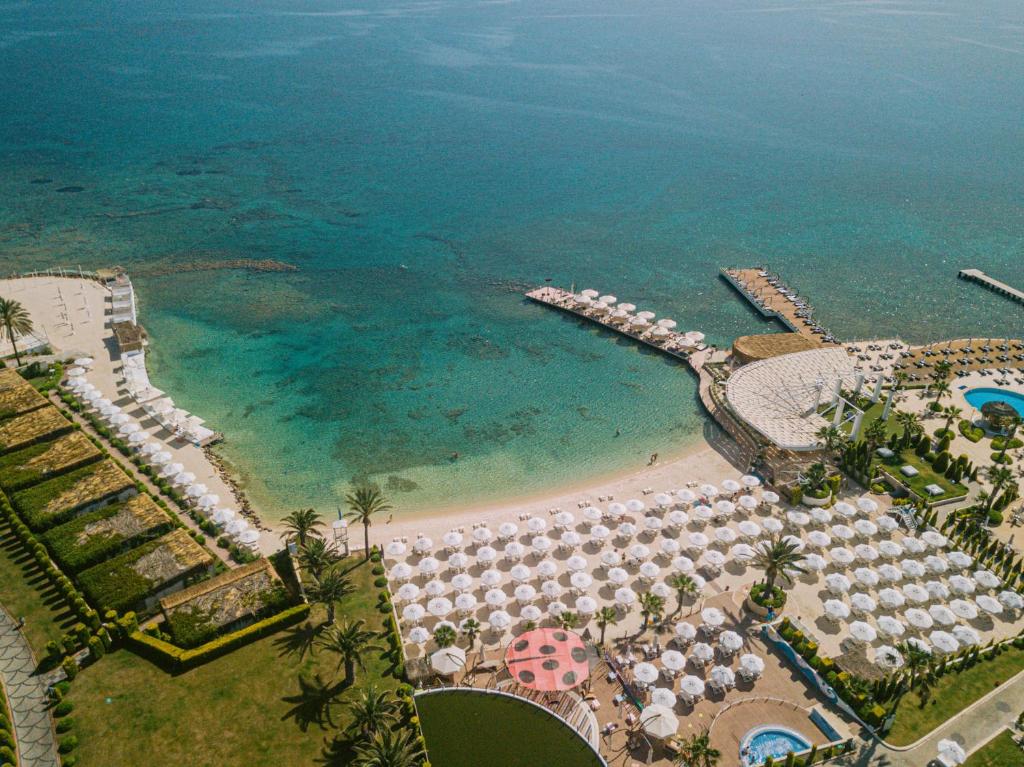 an aerial view of a beach with umbrellas and the ocean at Ilica Hotel Spa & Wellness Resort in Çeşme