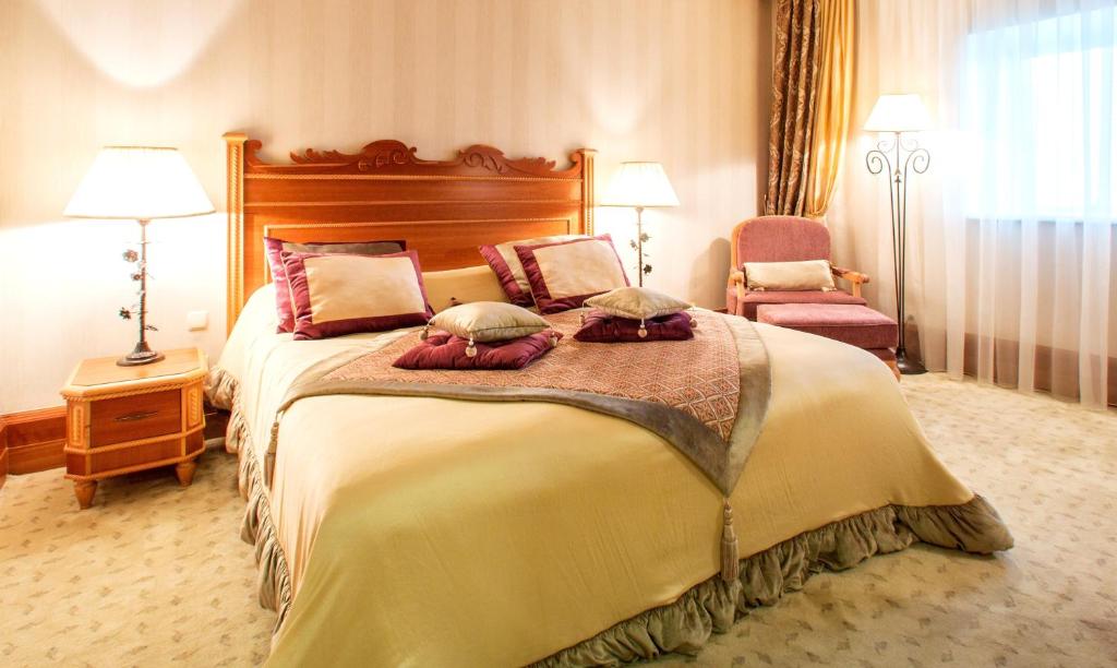 a hotel room with a large bed and a chair at Rixos-Prykarpattya Resort in Truskavets