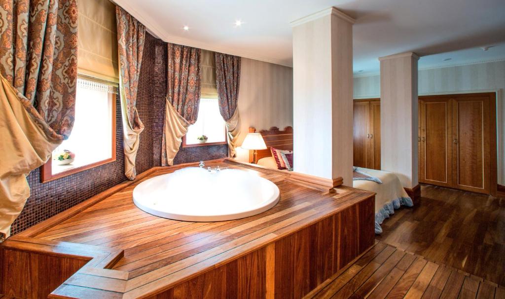 a bathroom with a bath tub with a sink at Rixos-Prykarpattya Resort in Truskavets