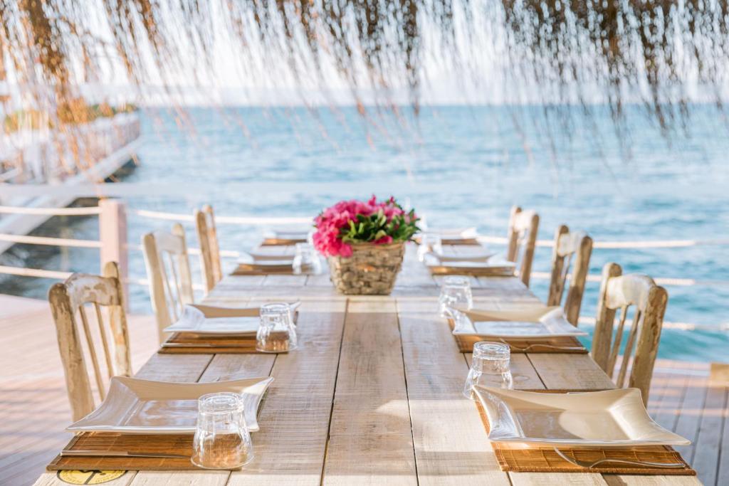 a long wooden table with chairs and a fountain at Ilica Hotel Spa & Wellness Resort in Çeşme