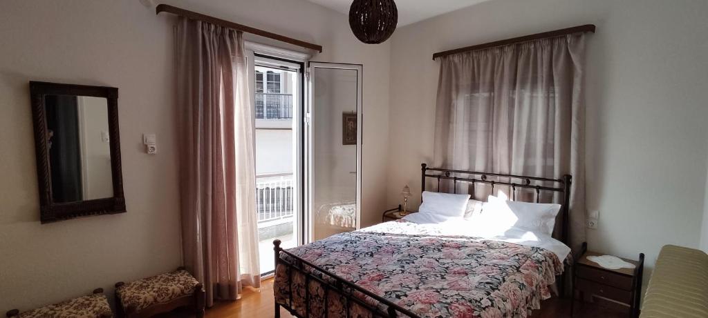 um quarto com uma cama e uma grande janela em Σπίτι στην πόλη Άρτα κοντά στην λίμνη em Arta