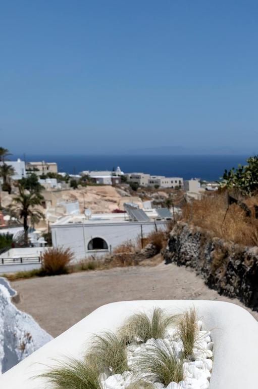 a view of a town with houses and the ocean at Acave Santorini Suites in Vóthon